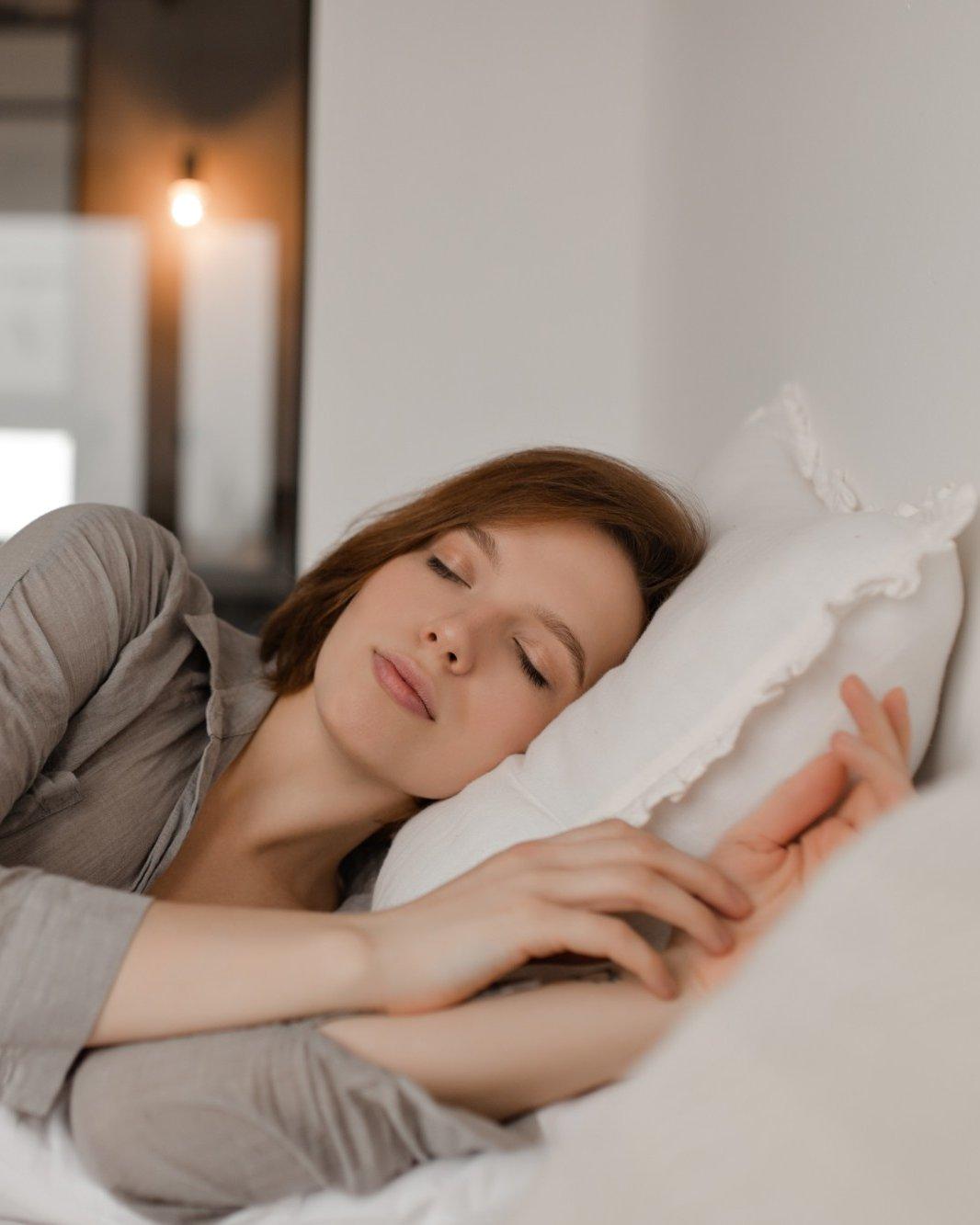 Person sleeping deeply on a bed with a DENBA Health mat